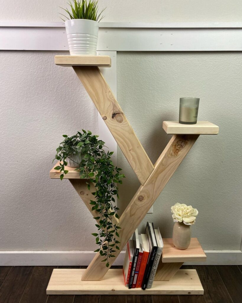Geometric 2x4 wooden plant stand with shelves holding various potted plants and books.