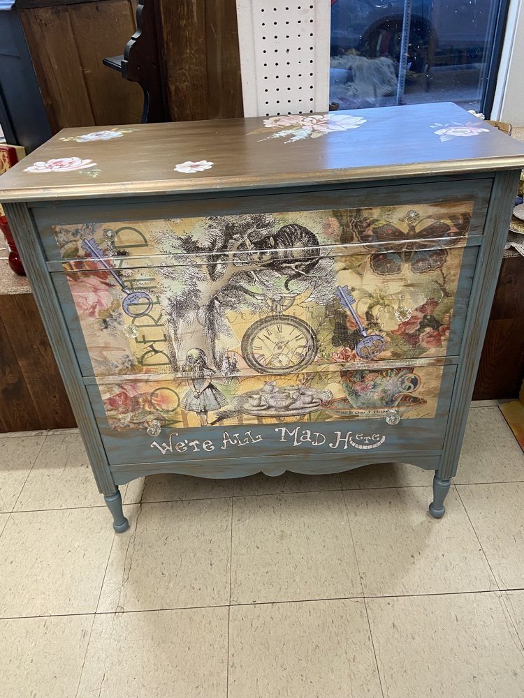 Grey painted dresser with a vintage-style decoupage image and whimsical text on the drawer.