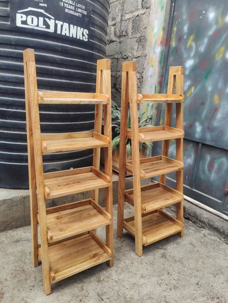 Two wooden ladder-style shoe racks with five shelves each standing outdoors.