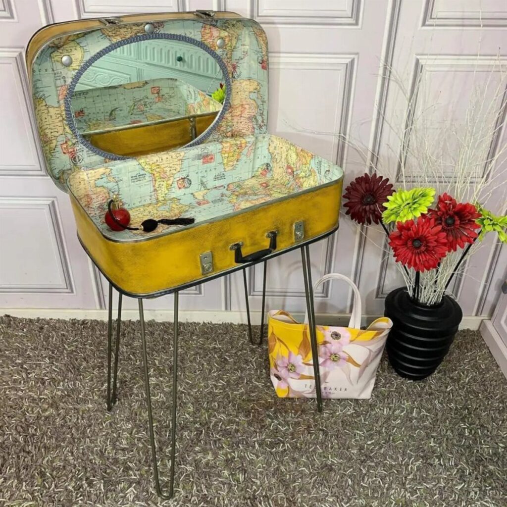 Yellow vintage suitcase side table with world map lining and thin metal legs.