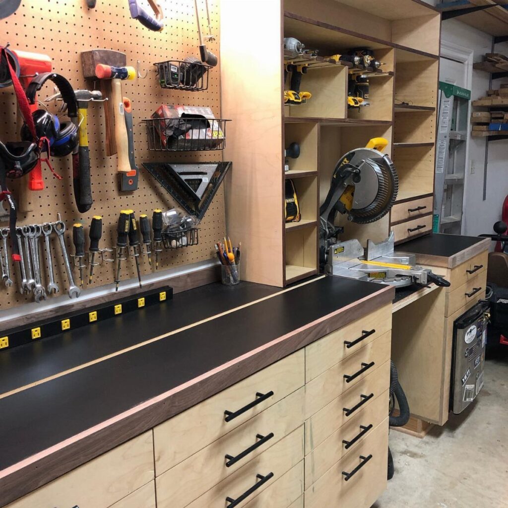 Miter saw integrated into a custom wooden storage cabinet with a black countertop.