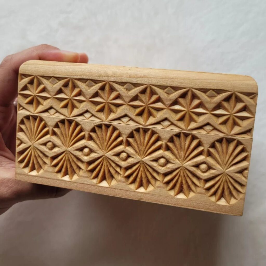 Wooden block with intricate geometric relief carvings of stars and floral patterns.