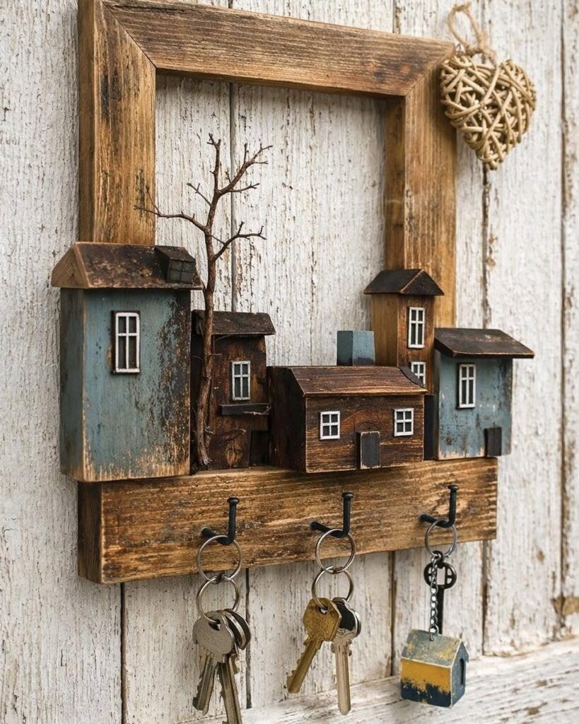 Rustic wooden wall-mounted key holder with miniature houses and keys hanging from hooks.