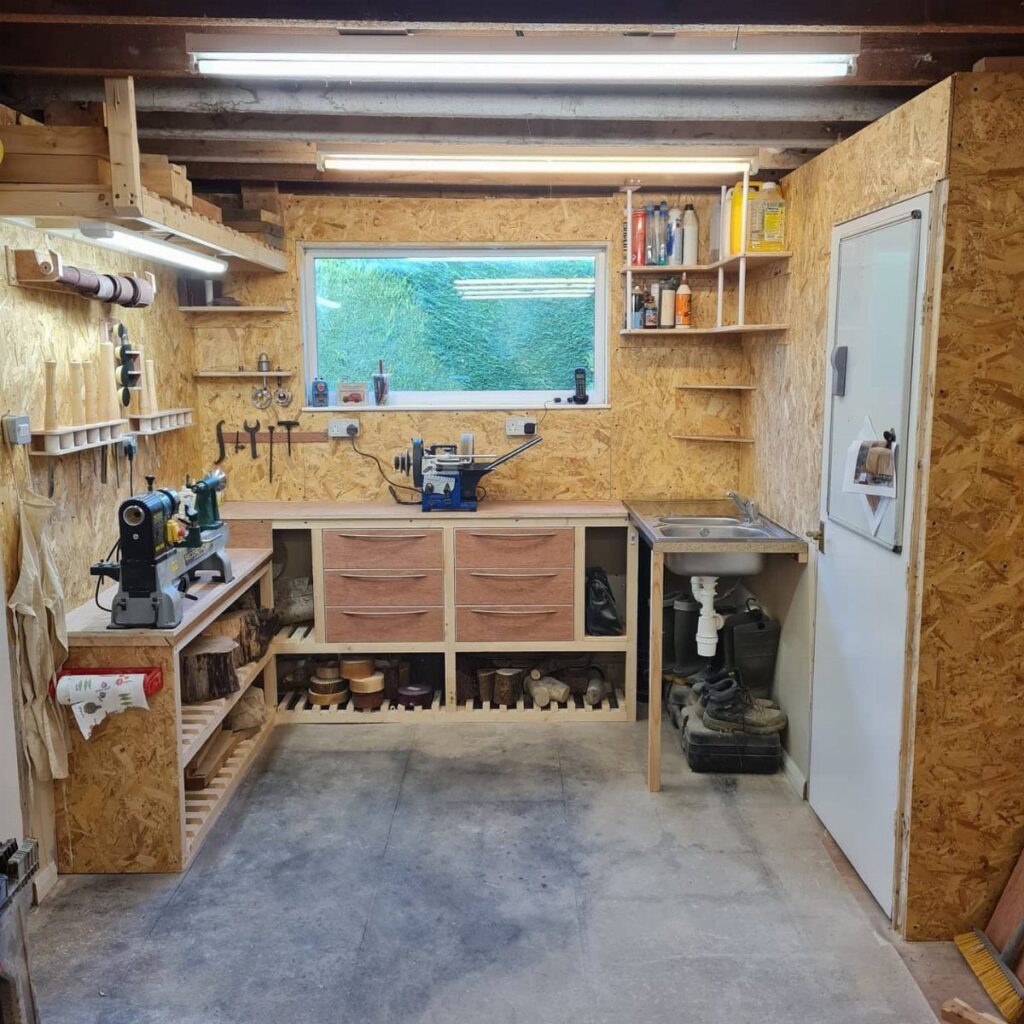 Woodworking shop with fluorescent overhead and task lighting illuminating a workbench and lathe