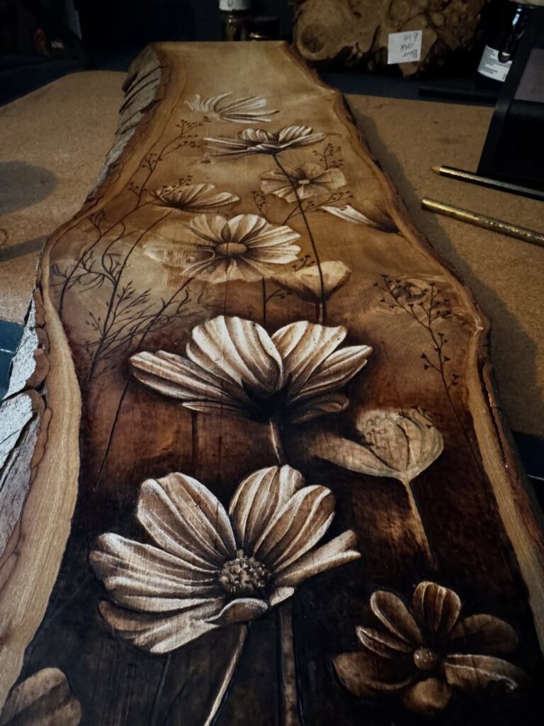 Detailed wood burning art of flowers on a natural brown wooden slab