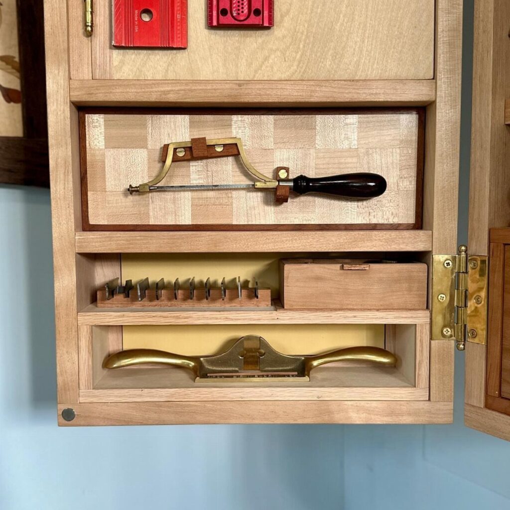 Wooden tool cabinet with organized woodworking tools in custom slots and compartments.